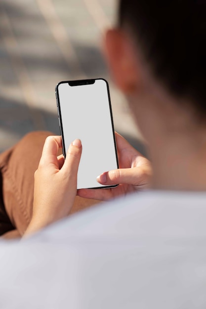 PSD vrouw die mock-up smartphone buitenshuis gebruikt