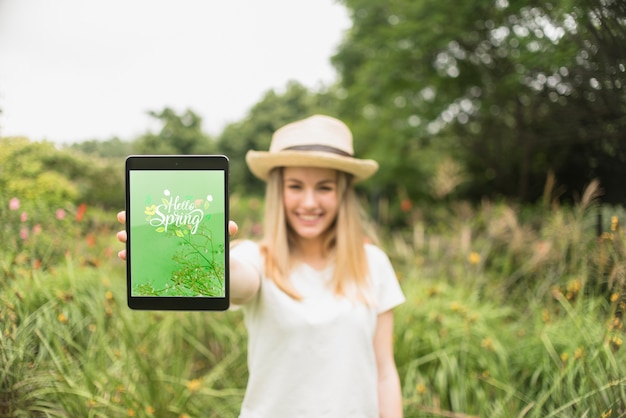 Vrouw die tabletmodel in aard voorstelt