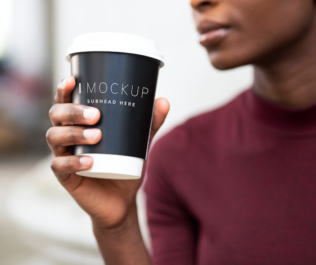 Vrouw het drinken koffie uit een papieren beker mockup