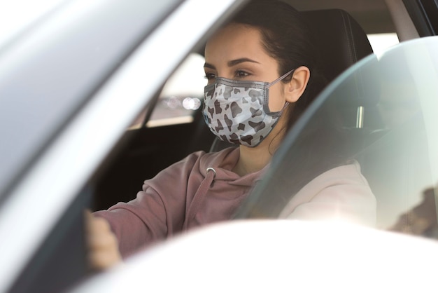 PSD vrouw in auto die masker draagt