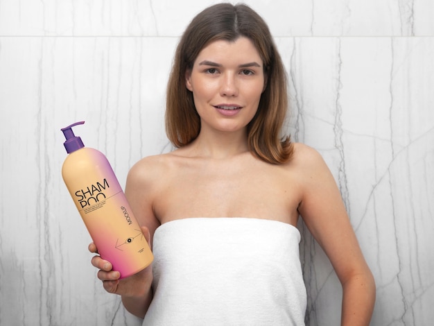 PSD vrouw in handdoek met mock-up fles shampoo