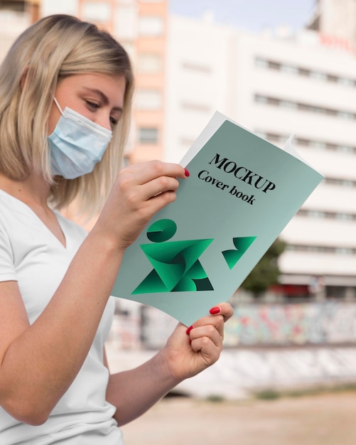 Vrouw met masker leesboek op straat