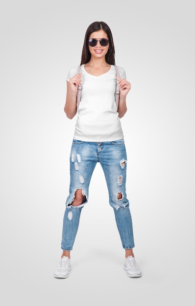 Vrouw met zonnebril, wit T-shirt en gescheurde spijkerbroek.