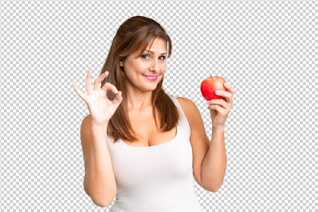 PSD vrouw van middelbare leeftijd met een appel op een geïsoleerde achtergrond met ok-teken met vingers