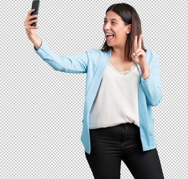 Vrouw van middelbare leeftijd zelfverzekerd en opgewekt, een selfie maken, naar de mobiel kijken met een grappig en zorgeloos gebaar, surfen op de sociale netwerken en internet