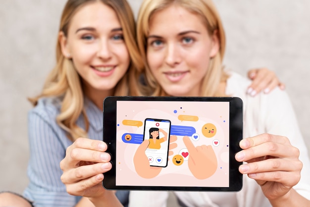 Vrouwen die een sociaal media concept op een tablet tonen