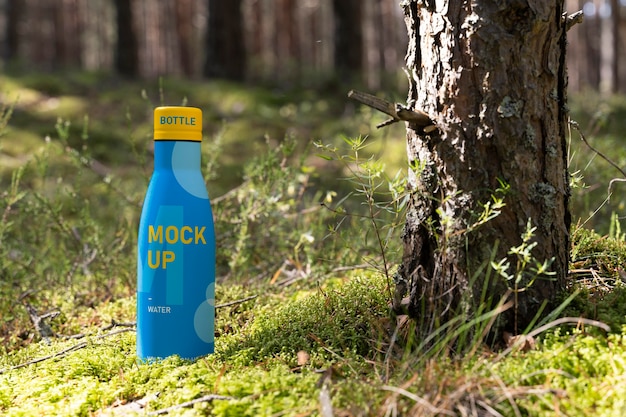 PSD water drop bottle mockup in nature