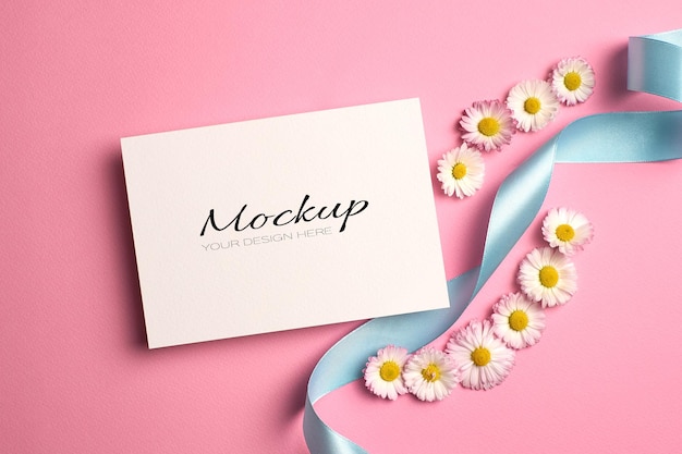 Wedding invitation card mockup with daisy flowers and turquoise ribbon on pink