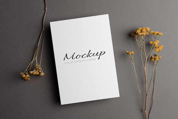 wedding invitation card mockup with dry flowers twigs on grey
