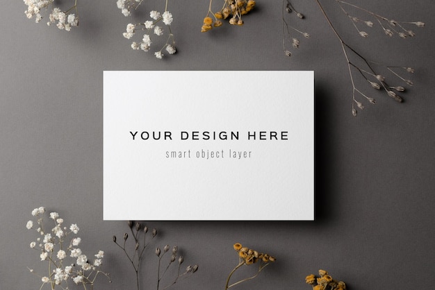 wedding invitation card mockup with dry flowers twigs on grey