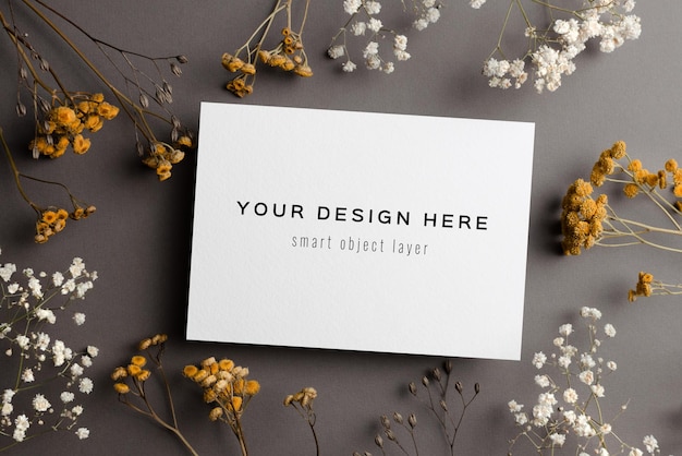 wedding invitation card mockup with dry flowers twigs on grey
