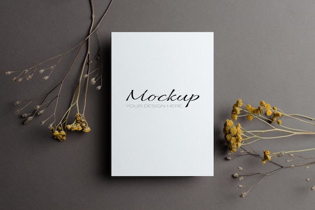 Wedding invitation card mockup with dry flowers twigs on grey