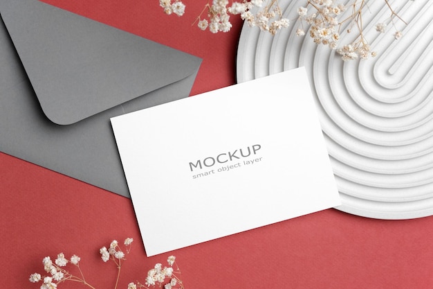 PSD mockup di biglietto d'invito per matrimonio con fiori in cartoncino bianco disteso con spazio per la copia