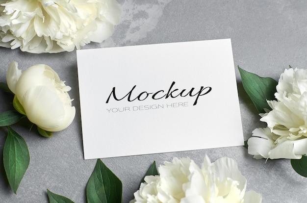 Wedding invitation or greeting card mockup with white peony flowers on grey