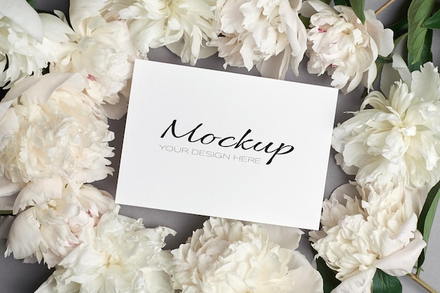 Wedding invitation or greeting card mockup with white peony flowers on grey