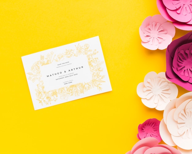 PSD wedding invitation mock-up with paper flowers on yellow wallpaper