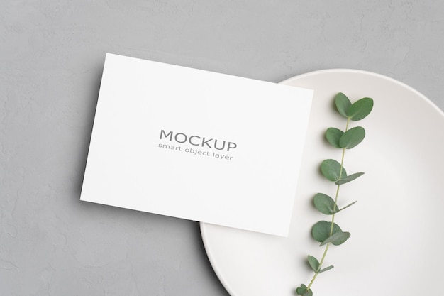 Mockup di biglietti d'invito per carta da matrimonio con ramoscello di eucalipto