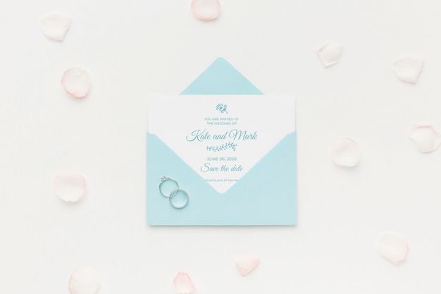 Wedding rings and invitation mock-up with petals