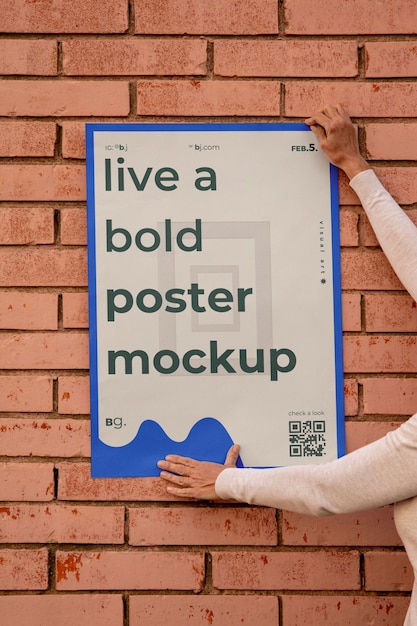 Weergave van een persoon die een buitenpostermodel op de muur plakt