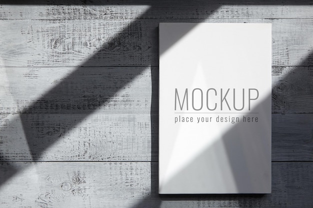 White blank canvas mockup hanging on grey wooden wall with shadows
