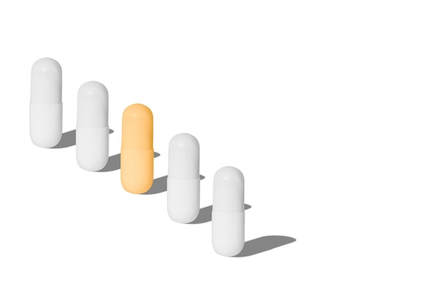White capsules and one yellow on isolated transparent background