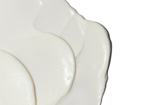 Crema cosmetica bianca spalmata su uno sfondo bianco