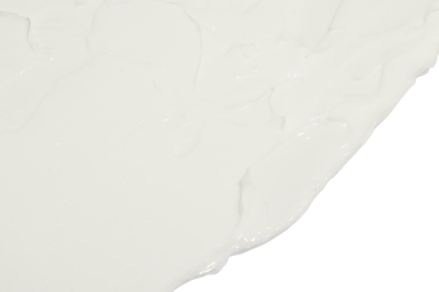 Белый косметический крем, намазанный на белом фоне