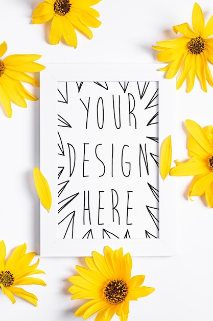 PSD white empty picture frame mock up with yellow flower on white, flat lay