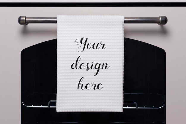 PSD white kitchen towel hangs on the oven handle, product mockup.