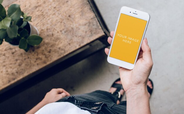 White Phone Screen Mockup Held in Hand at Loft Home