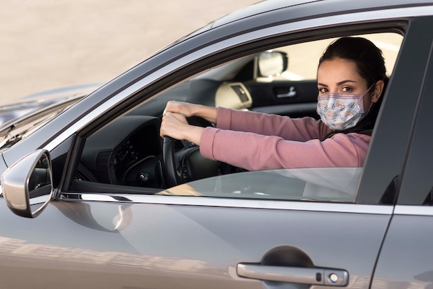 医療マスクを身に着けている車の中で女性