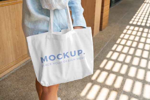 woman carrying a white tote bag mockup