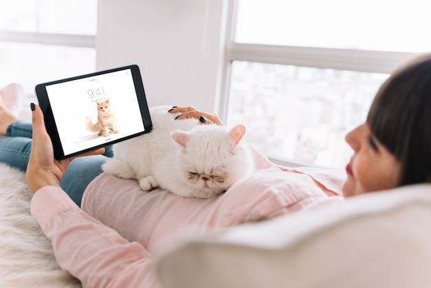 PSD donna sul divano con gatto e tablet mockup