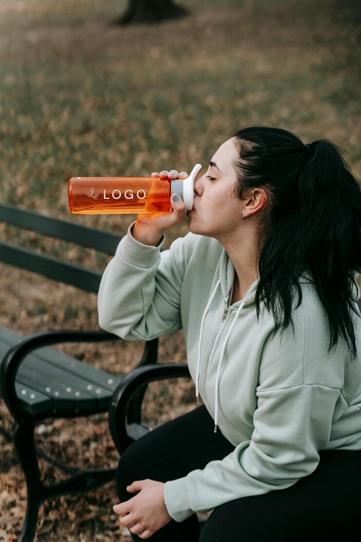 PSD woman drinking from a water bottle in the park