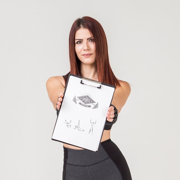 PSD woman in gym clothes holding notepad