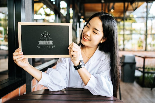 Woman hand holding Chalkboard PSD Mockup