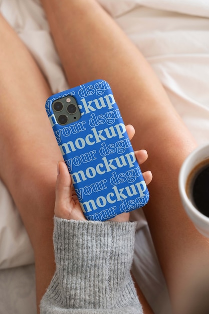 Woman hand holding smartphone mock-up indoors