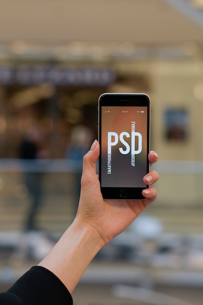 PSD mano della donna che tiene smartphone e che mostra schermo