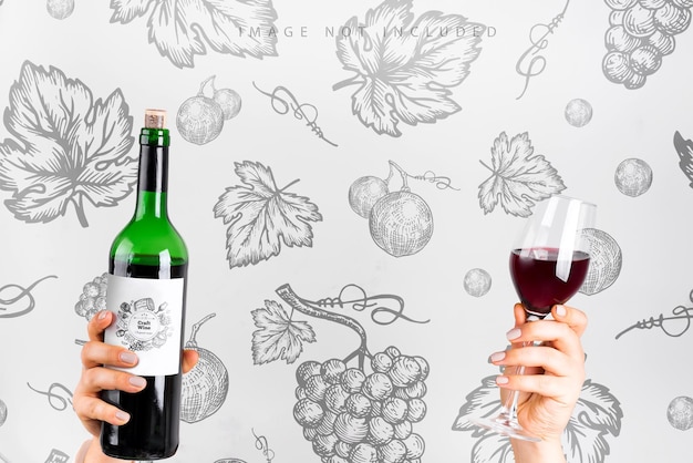 PSD a woman hands holds glass with red wine and wine bottle mockup