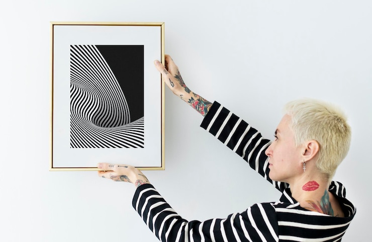 PSD woman hanging a photo frame on a white wall