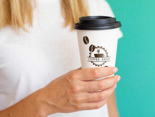 PSD Женщина держит макет бумажный стаканчик кофе