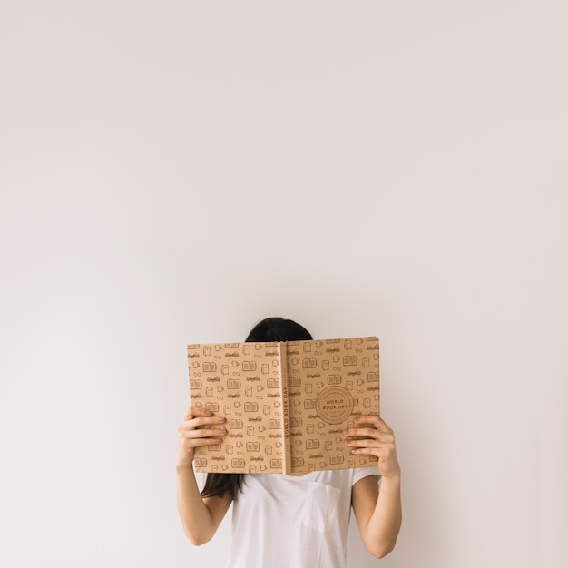 Woman holding book cover mockup