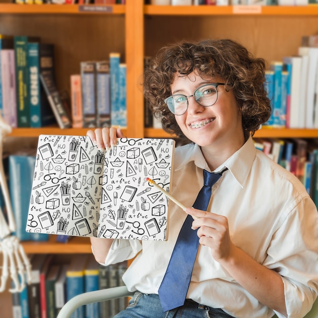 Woman holding book mockup in library