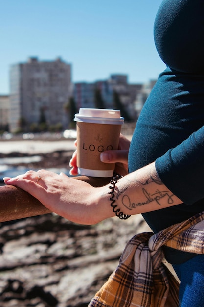 a woman holding a coffee cup with the word on it on it