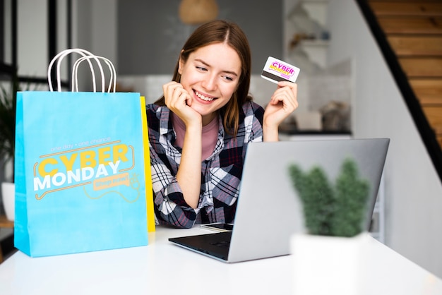 Woman holding a credit card and looking on laptop