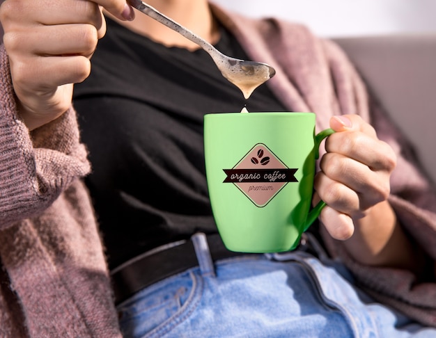 Woman holding green coffee mug