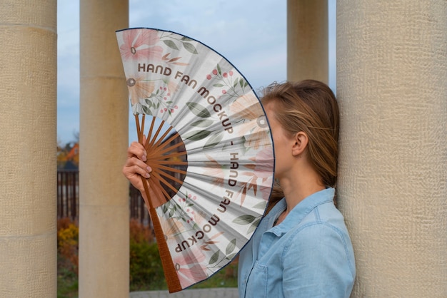 Woman holding hand fan with mock-up design