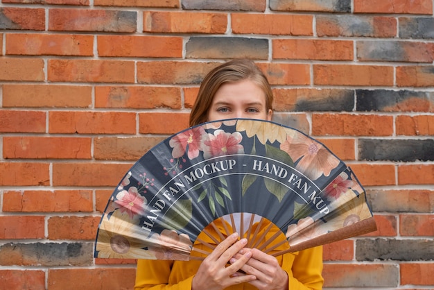 PSD woman holding hand fan with mock-up design