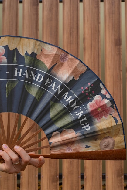 Woman holding hand fan with mock-up design