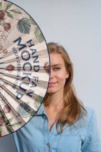 Woman holding hand fan with mock-up design